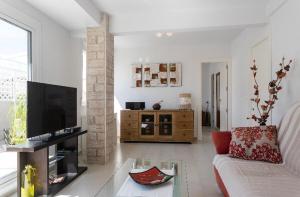 un soggiorno con divano e TV di Pretty penthouse Alicante ad Alicante
