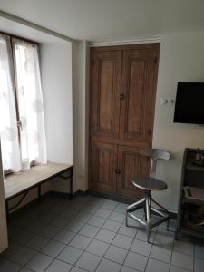 オーヴィエにあるCottage AU TERMINUSのデスクと椅子、木製のドアが備わる客室です。