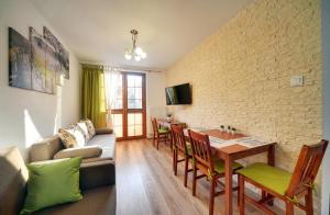 ein Wohnzimmer mit einem Sofa und einem Tisch in der Unterkunft Apartamenty EverySky Nadrzeczna 3E-3D in Karpacz