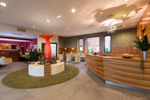 a restaurant with a red vase in the middle of a lobby at Hotel Süd Graz in Graz +104 photos
