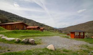 a gravel road in a field next to buildings at Paraiso Rural in Villanueva de Cameros