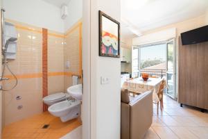 a bathroom with a sink and a toilet and a table at Villa Maria Apartments nel Cuore di Riccione in Riccione