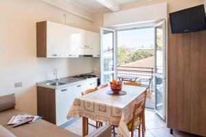 a kitchen and dining room with a table and a balcony at Villa Maria Apartments nel Cuore di Riccione in Riccione +24 photos