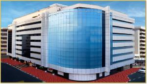 a tall building with a lot of glass windows at Vision Imperial Hotel Formerly Excelsior Hotel Downtown in Dubai