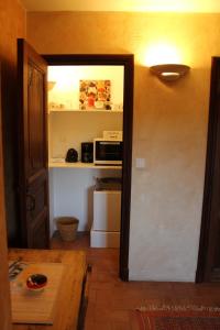 a room with a door open to a kitchen with a microwave at B&B Jardins de Vies in Flayosc