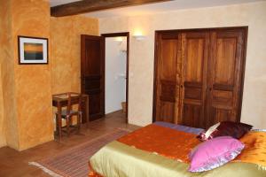 a bedroom with a bed and a table and a door at B&B Jardins de Vies in Flayosc