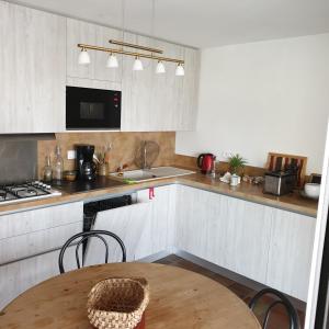 a kitchen with white cabinets and a wooden table at Oustal in Savines