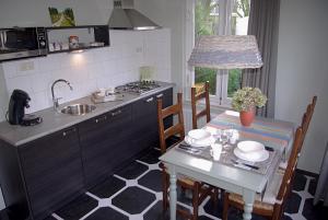 a kitchen with a table and a sink and a stove at Logies Taverne nearby Roermond, Thorn en Weert in Kelpen-Oler