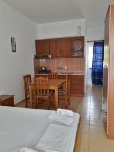 uma cozinha e sala de jantar com mesa e cadeiras em Rooms and Apartments Analipsi em Shëngjin