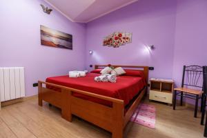 a bedroom with a bed with red sheets and a tv at Rio Launaxi Guest House in Teulada