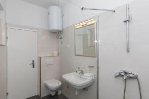 een witte badkamer met een toilet en een wastafel bij Guest House Libertas in Dubrovnik