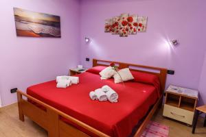 a bedroom with a red bed with towel animals on it at Rio Launaxi Guest House in Teulada