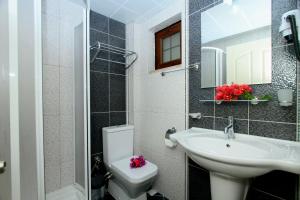 a bathroom with a sink and a toilet and a mirror at Akyaka Deger Apart in Akyaka +23 photos