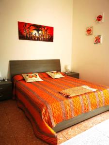 a bedroom with a large bed with an orange comforter at Tenente Amendola 2 in Lipari