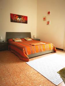 a bedroom with a bed with an orange comforter at Tenente Amendola 2 in Lipari
