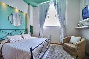 una camera con un letto e una sedia e una finestra di Palazzo Frigo a Montefiascone