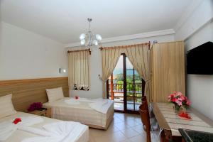 a hotel room with two beds and a balcony at Akyaka Deger Apart in Akyaka
