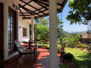 a porch with a table and a bench on it at Pearl House in Kandy