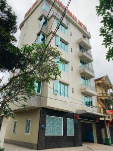 榮市的住宿－Hoang Ngan 1 Hotel - TP. Vinh，一座高大的白色建筑,有很多窗户