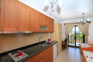 a kitchen with wooden cabinets and a sink at Akyaka Deger Apart in Akyaka