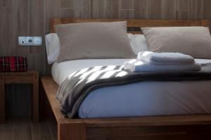 a bed with two towels on top of it at Bufones de Pria Apartamentos Rurales in Garaña