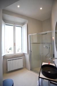 une salle de bain avec une douche en verre et un lavabo dans l'établissement Suite Calderini, à Pérouse 23 autres photos