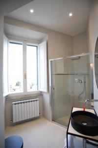 a bathroom with a glass shower and a sink at Suite Calderini in Perugia