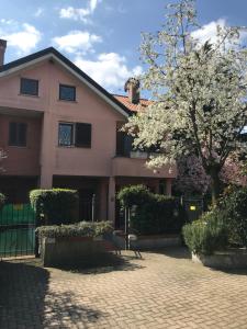 une maison avec un arbre à fleurs devant elle dans l'établissement B&B Borgo dei Fiori, à Rozzano