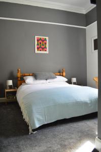 Briar Brae Bed & Breakfast في سترانراير: غرفة نوم بسرير كبير مع بطانية زرقاء