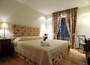 Un dormitorio con una cama y una mesa con flores. en Boutique Hotel Kentrikon & Bungalows, en Agios Ioannis