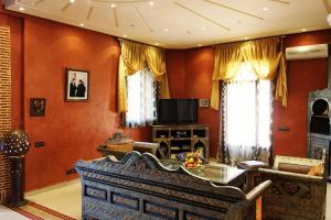 een woonkamer met oranje muren en een bank bij Palais Dar Ouladna in Marrakesh