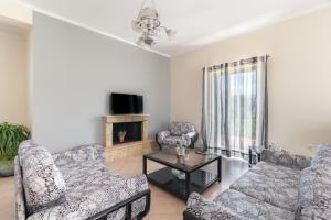 a living room with two couches and a tv at VILLA ELENI in Zacharo