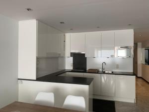 a kitchen with white cabinets and a black counter top at Mauritius 11 in Knokke-Heist