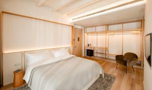 a bedroom with a white bed and a chair at 88 Armenian in George Town