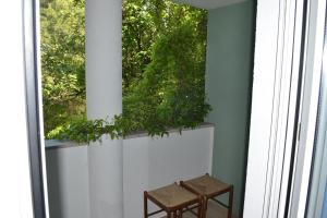 a pair of stools sitting in front of a window at Villa Verde Apartments and Rooms in Premantura