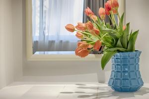 a blue vase filled with orange tulips in front of a window at Luna Miramar Club in Albufeira