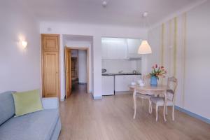 a living room and kitchen with a table and a couch at Luna Miramar Club in Albufeira