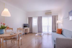 a living room with a blue couch and a table at Luna Miramar Club in Albufeira