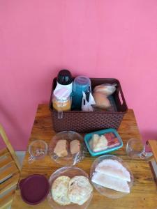 einen Tisch mit einem Korb mit Essen und Brot in der Unterkunft Pousada Ilha Bella in Galinhos