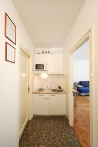 a small kitchen with a sink and a microwave at Sea Organ Apartment 1 & Garage for Free - Oldtown in Zadar