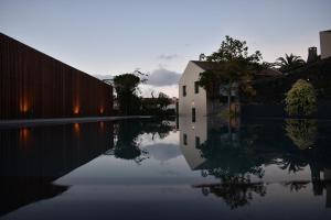 a reflection of a building in a body of water at Volcanic Charming House in Ribeira Grande
