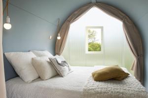 um quarto com uma cama e uma janela grande em Camping le Rouge Gorge **** 10' Puy du Fou em Saint-Laurent-sur-Sèvre