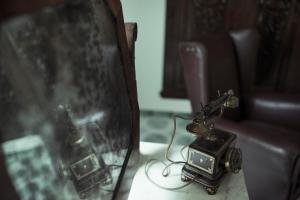 an old telephone sitting on a table next to a mirror at Villa delle Querce Resort in Palo del Colle