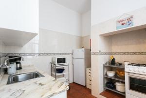 une petite cuisine avec un évier et un réfrigérateur dans l'établissement FLH Rossio's Flat, à Lisbonne 8 autres photos