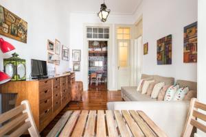 een woonkamer met een bank en een tv bij FLH Rossio's Flat in Lissabon