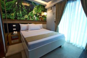 a bedroom with a bed with a painting on the wall at Eurotel Boracay in Boracay