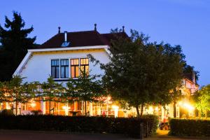 a white house at night with lights at Hotel Restaurant Taverne in Twello