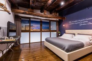 a bedroom with a bed and a desk and windows at B&B i Maestri in Naples
