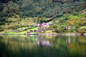 a group of houses on a hill next to a lake at Solhaug Fjordcamping in Geiranger