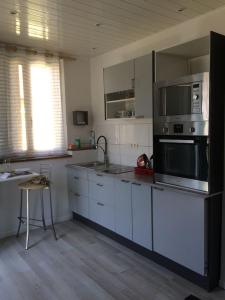 a kitchen with white cabinets and stainless steel appliances at Studio Bassens in Bassens